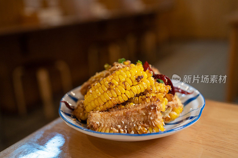 油炸和烤玉米，大蒜和干辣椒的盘子与孤立的模糊背景