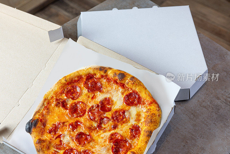 圆形烤腊肠披萨在送货盒