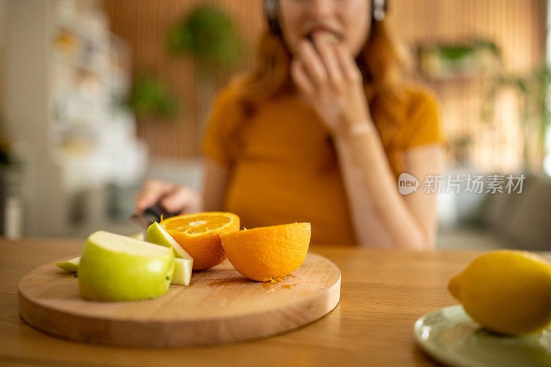 年轻女子在家里吃水果当早餐