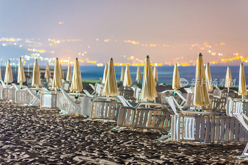 夜景，有躺椅和海边的沙滩伞。Agropoli。意大利。第勒尼安海。海滩。星星