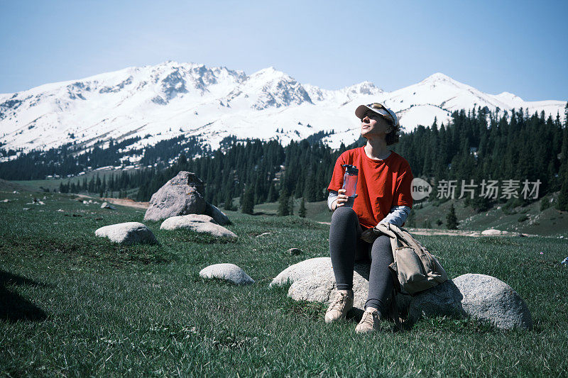 女徒步旅行者正在山里喝水