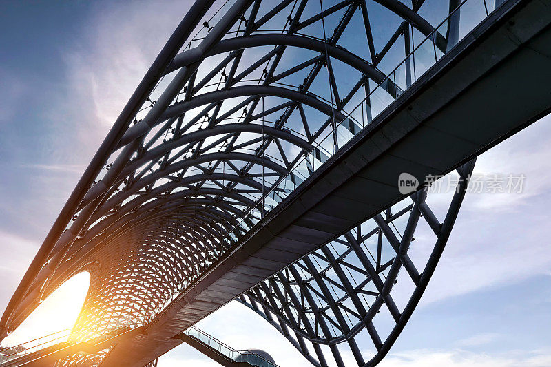 一座漂亮的玻璃钢人行桥，有玻璃屋顶。