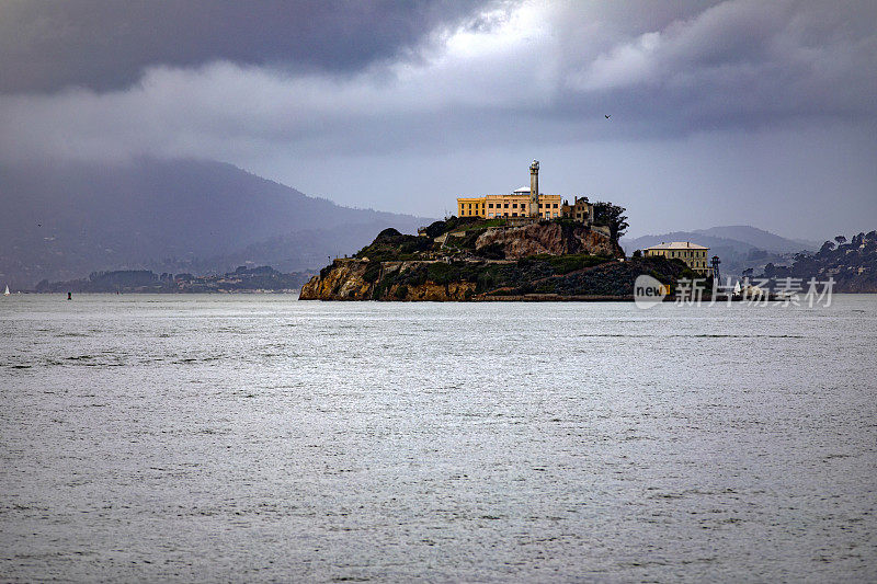 多云的天空下，美国加利福尼亚州旧金山湾中部著名的恶魔岛及其联邦监狱。美国最高安全级别的监狱。