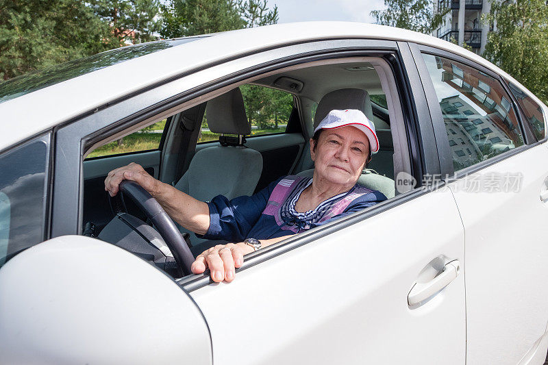 一位77岁的老妇人开着车，看着窗外。