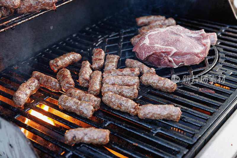 在烤肉架上与红肉牛排一起烤的碎牛肉卷