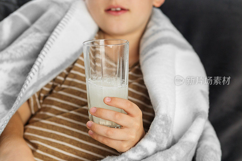 儿童手中的一杯含维生素C的水。季节性感冒。