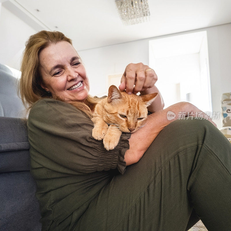 女人和他的姜黄色猫在家里。