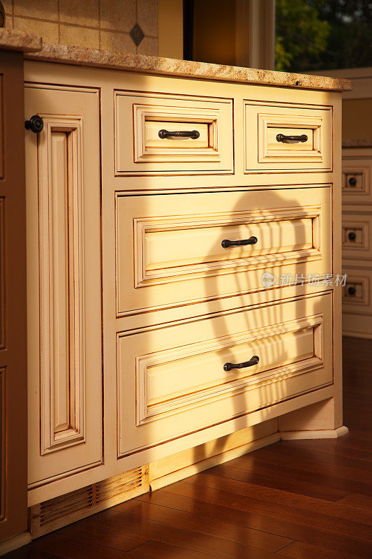 柔和的光线照射在一个新的定制厨房橱柜上。