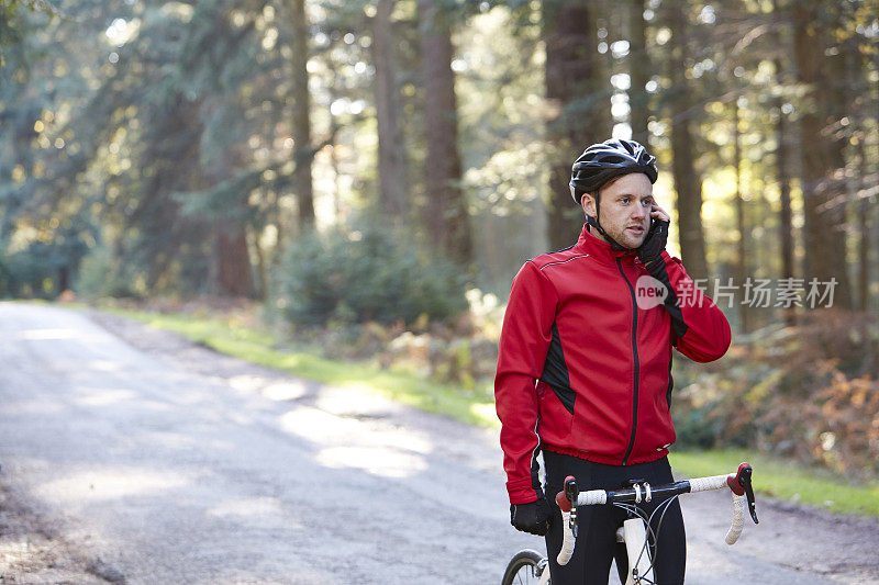 骑自行车的人在自行车上使用手机