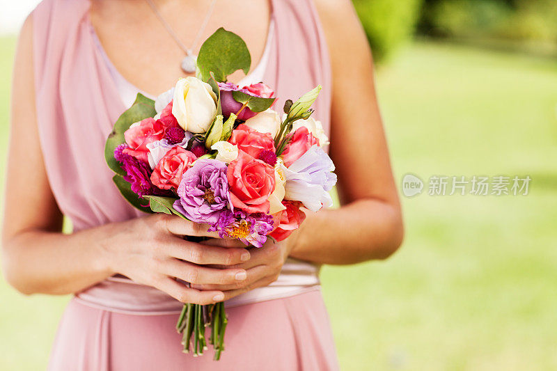 在花园婚礼上，伴娘手持花束