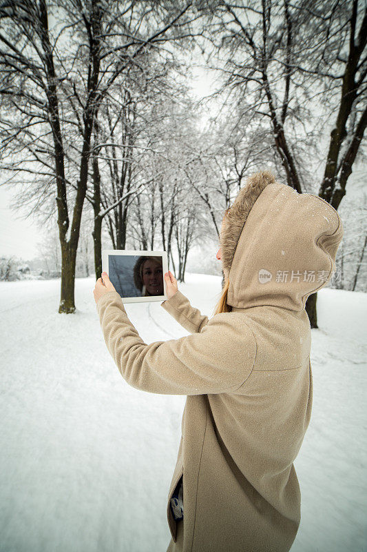 一名女子用平板电脑拍照――下雪的冬日