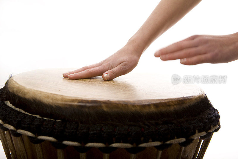 一个少年在弹奏djembe