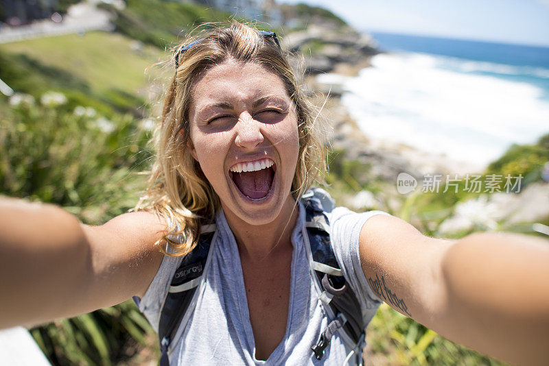 女性独自背包旅行者自拍大笑海洋