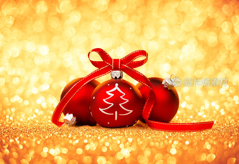 三个红色的带丝带的小玩意，圣诞树上的装饰品