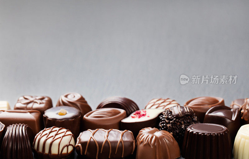 各式各样的糖果，白色，黑色，牛奶巧克力糖果的背景