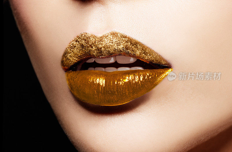 金色艺术嘴唇的特写。化妆美容形象。