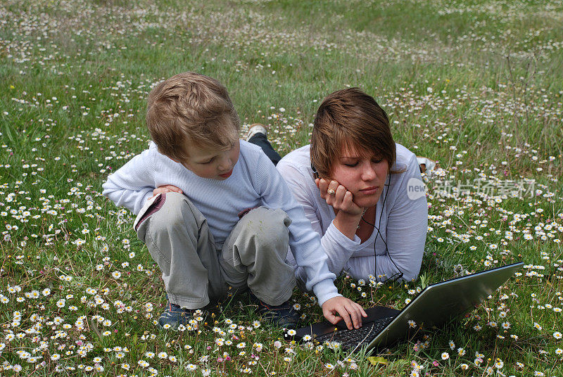 年轻的母亲和男孩在玩笔记本电脑