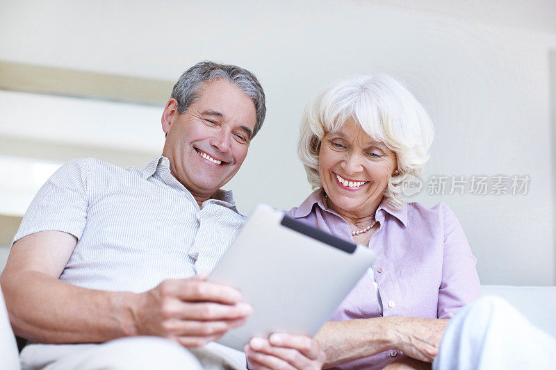 一对老年夫妇一起使用平板电脑