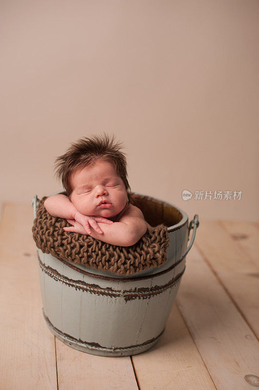 睡在桶里的新生儿