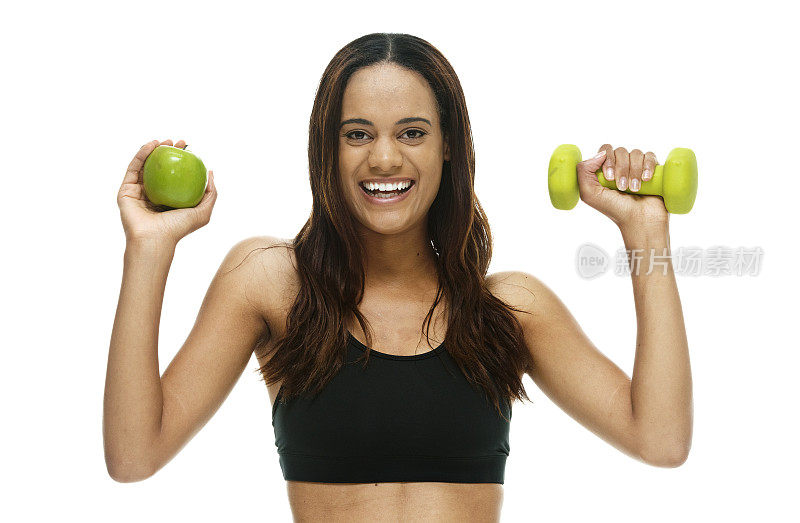 兴高采烈的女运动员拿着苹果和哑铃