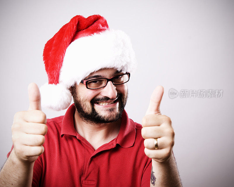 戴着圣诞帽竖起大拇指的快乐男人