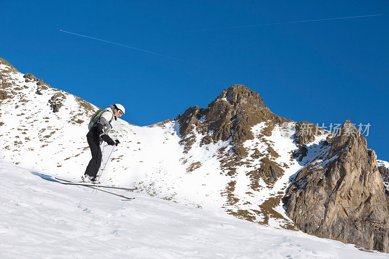 在阳光明媚的滑雪胜地滑雪的中年妇女滑雪
