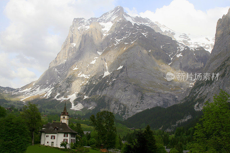 童话般的风景:上面田园诗般的格林德沃阿尔卑斯村庄教堂，山谷和草地，戏剧性的瑞士雪顶Wetterhorn尖峰阿尔卑斯山，田园诗般的乡村，伯恩斯高地，瑞士阿尔卑斯山