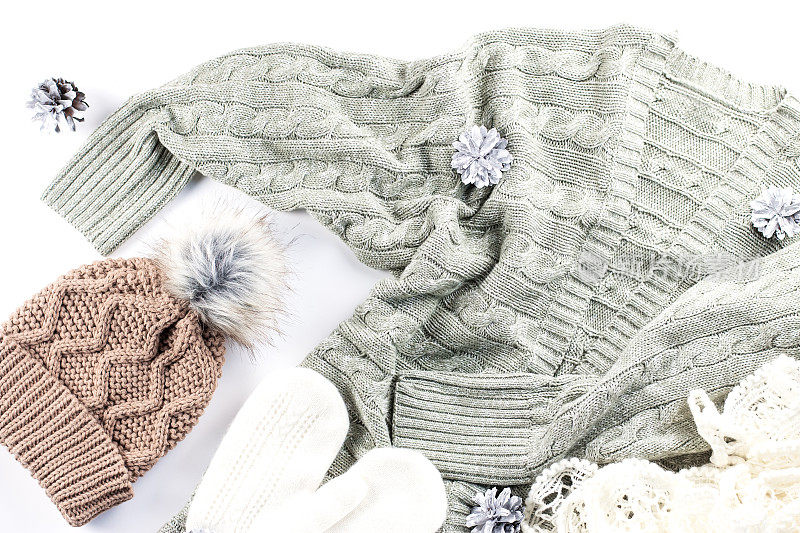 冬季时尚概念平铺。温暖、舒适的冬季服装，白色背景上的圣诞装饰品