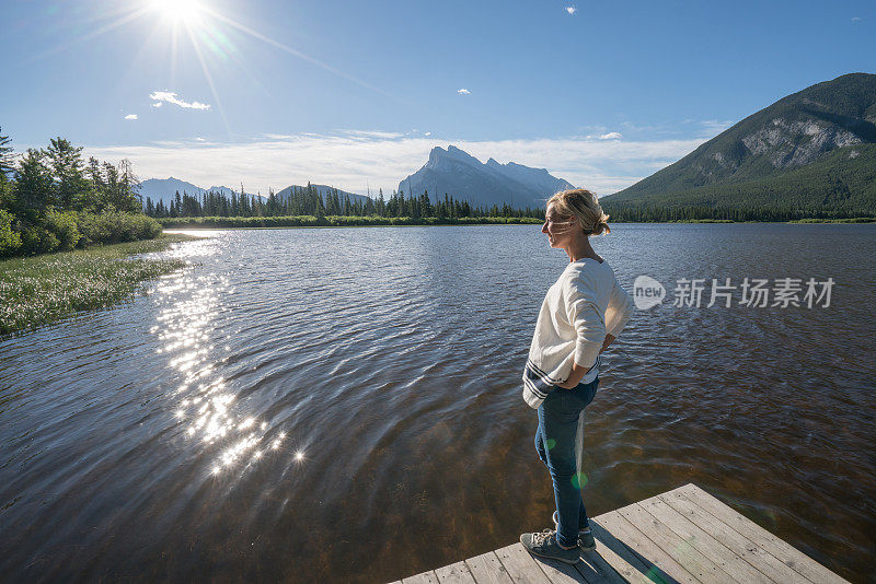 年轻女子在湖边码头凝望大自然