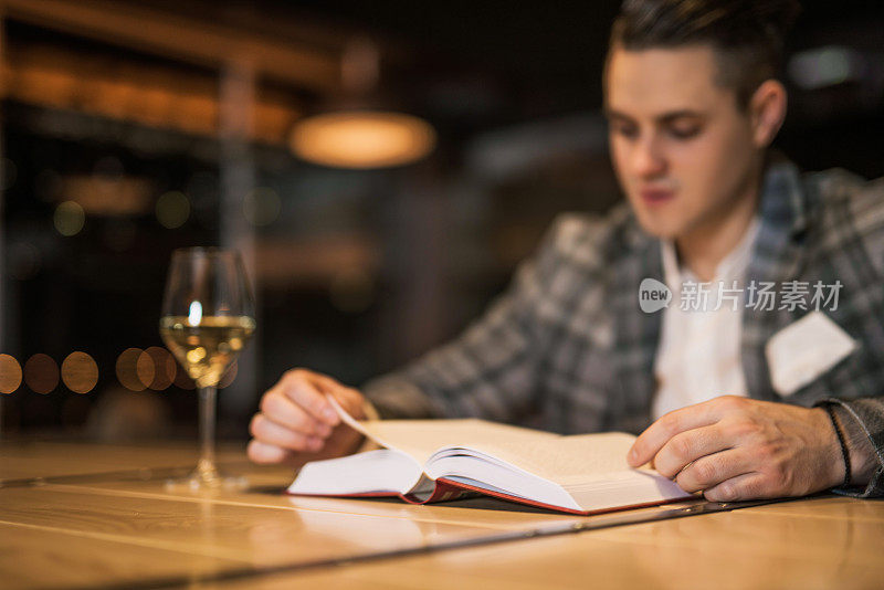 一个年轻人正在酒吧里看书。