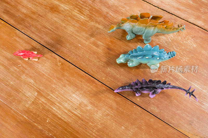 收集明亮的彩色玩具恐龙在木制桌面上