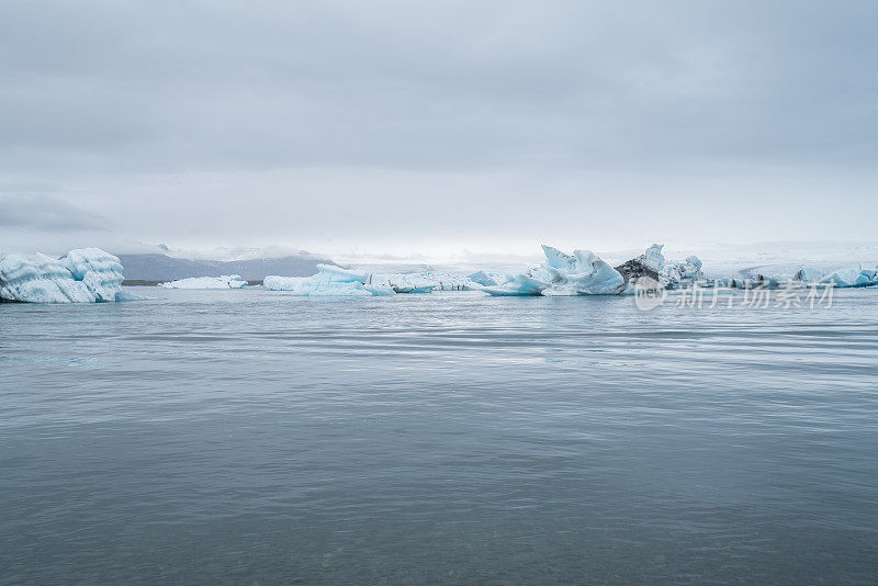 冰岛冰川泻湖的壮观景象与冰山漂浮在水上，阴天