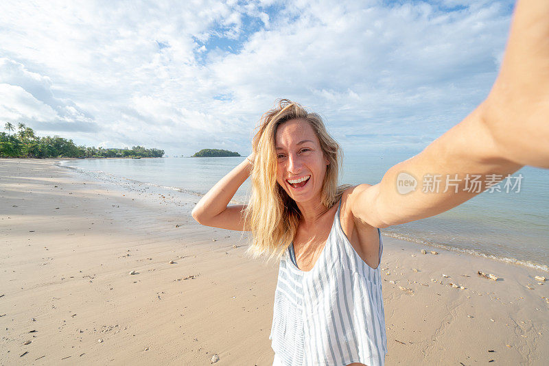 一名年轻女子在泰国海滩上自拍。人们旅行豪华度假乐趣和酷的态度概念