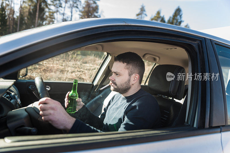 一边开车一边喝啤酒的男人