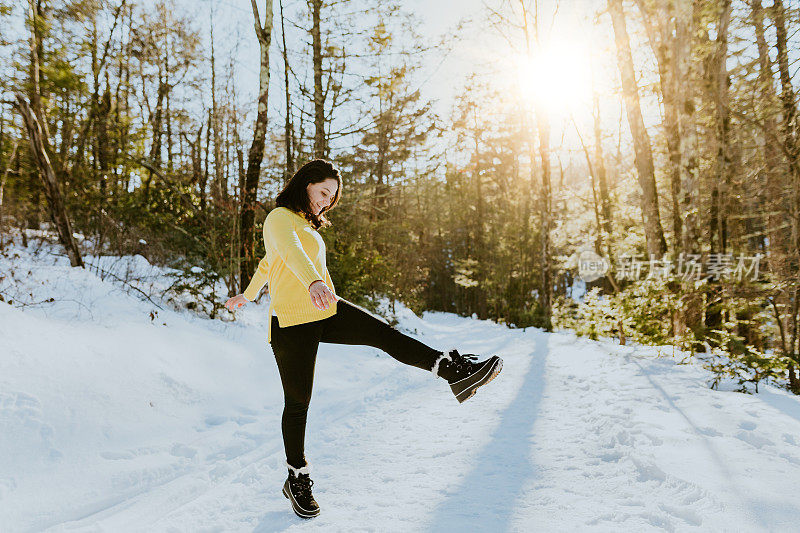 女人在雪地上蹦蹦跳跳