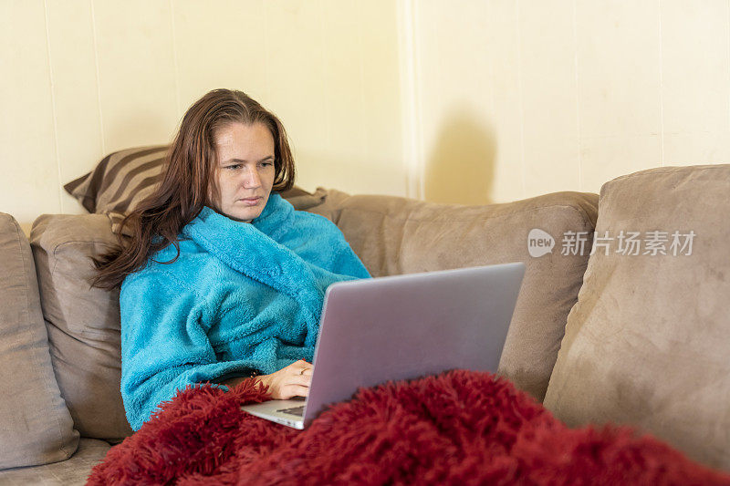 年轻女子在家生病时使用笔记本电脑