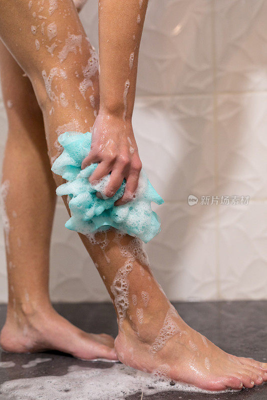 洗澡用海绵洗腿的女人