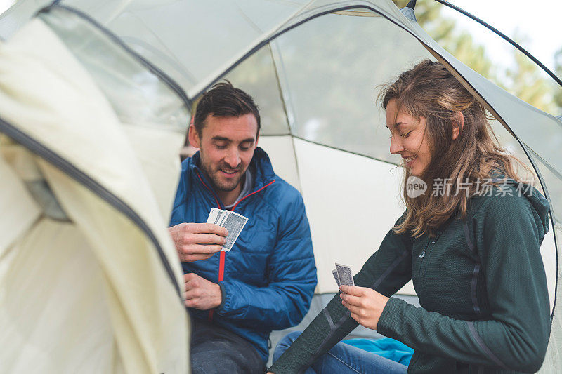 一对千禧一代夫妇在露营旅行中在帐篷里打牌