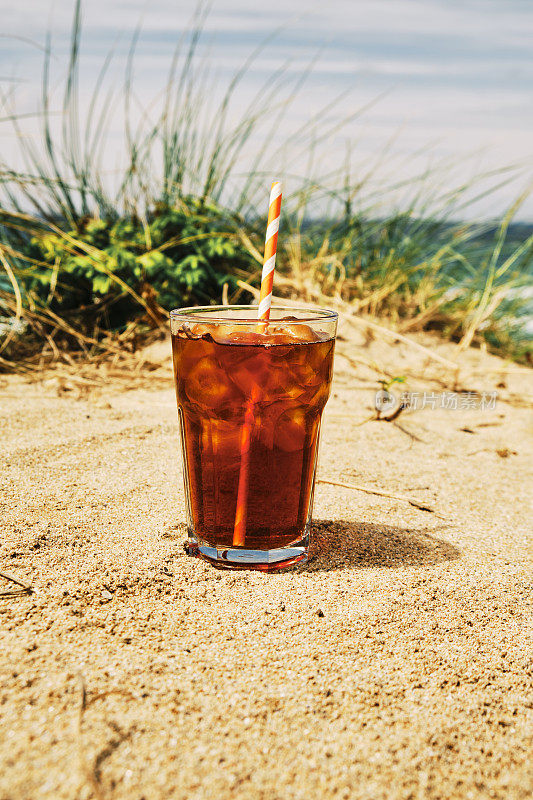 在一个炎热阳光明媚的夏日，在纽基菲斯特拉海滩的沙丘上喝一杯冰黑咖啡。