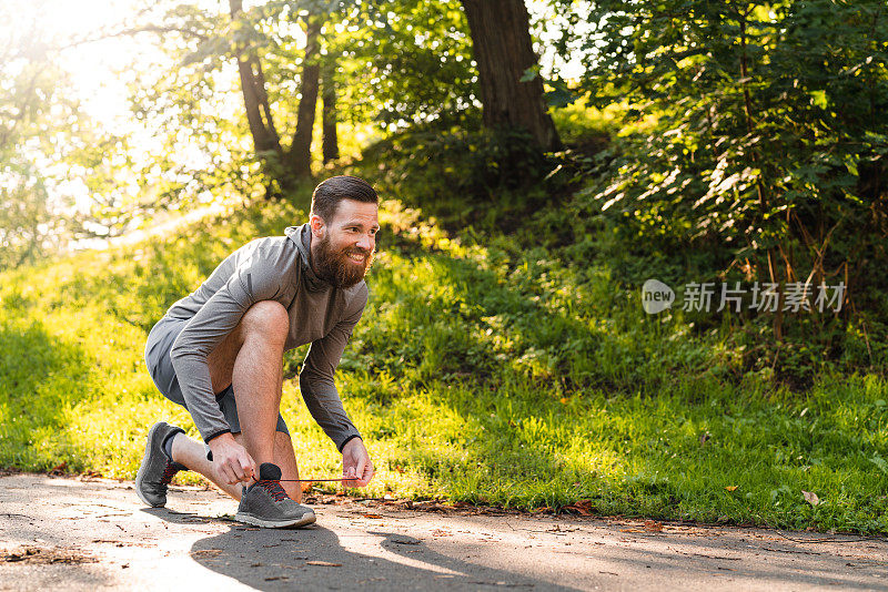 一名瑞典男子在公园锻炼前系鞋带