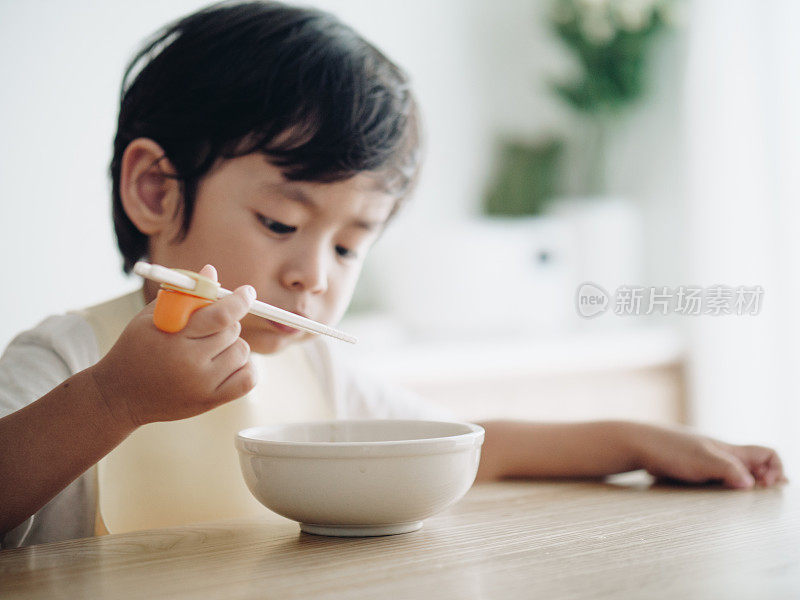 微笑的小男孩在高椅子上吃