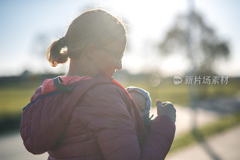 女人和她的孩子享受户外在一个寒冷的秋天日落