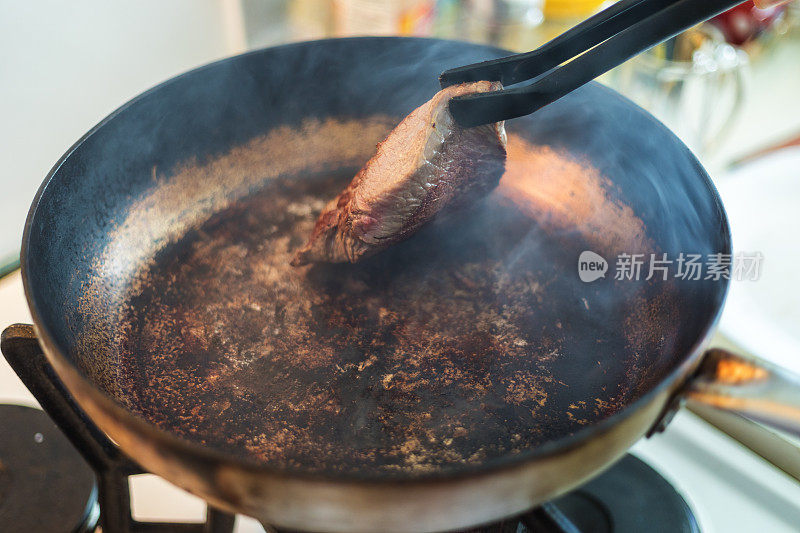 臀部牛排在金属锅里烤，特写