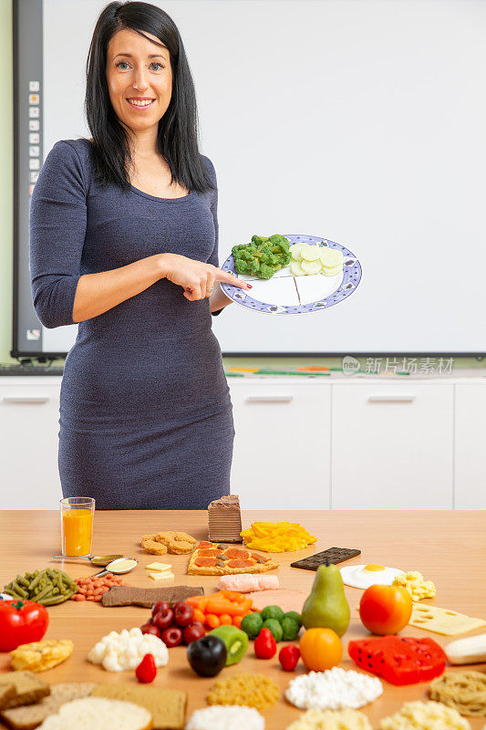 一位女性营养学家关于平衡饮食教育的垂直肖像-库存照片
