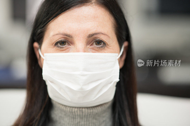 新型冠状病毒肺炎隔离。2019冠状病毒病隔离中戴口罩的中年妇女画像