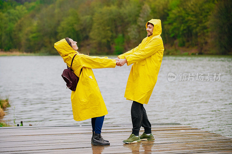 一对穿着雨衣的幸福夫妇站在码头上