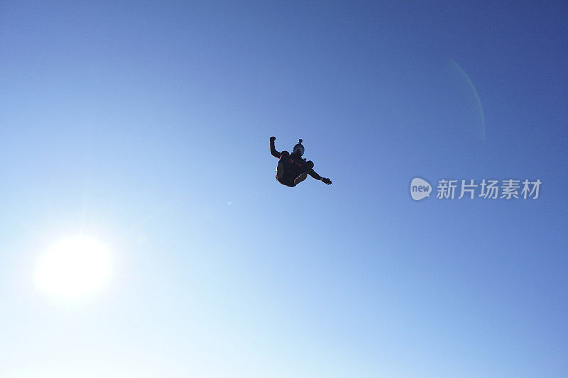 跳伞者从晴朗的天空坠落，空中飞行