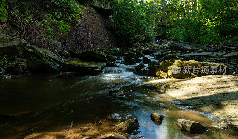 森林中的碎石坡上长满了苔藓的巨石，其间流淌着小河和小瀑布