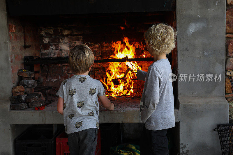 男孩子们在烧烤前玩火