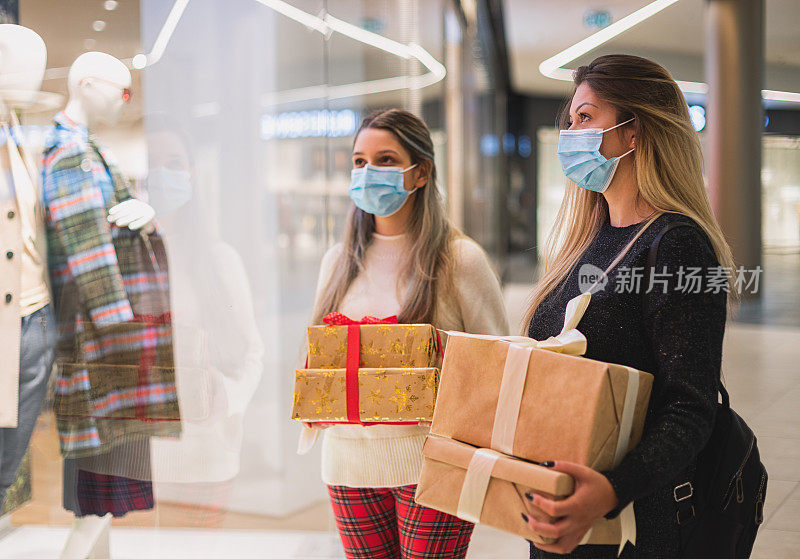2019冠状病毒病大流行期间，一家人在商场享受圣诞购物。他们戴着防护口罩，以防止冠状病毒感染。